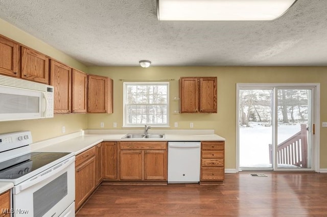 kitchen with sink, a textured ceiling, and white appliances