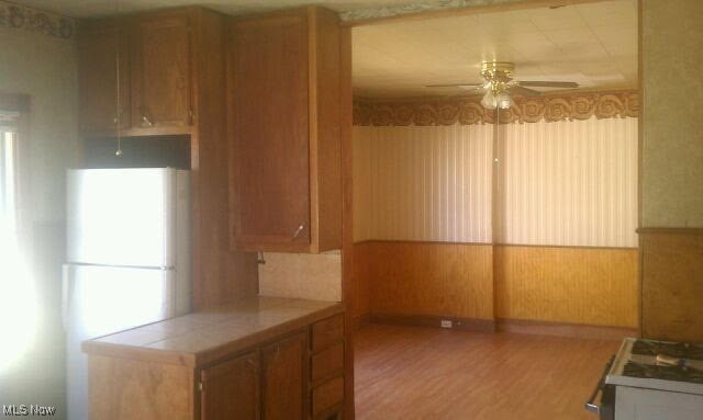 kitchen featuring a healthy amount of sunlight, tile countertops, and ceiling fan