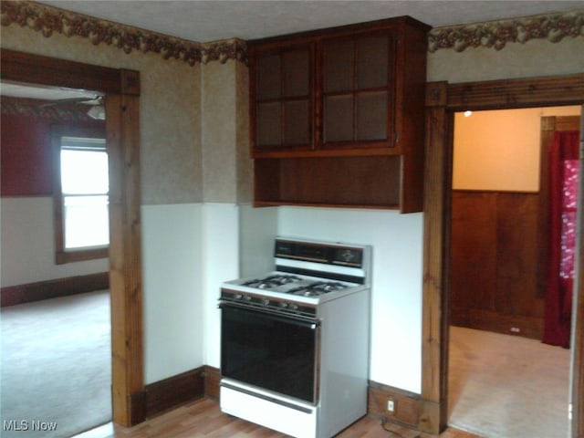 kitchen with light hardwood / wood-style floors and white range with gas stovetop