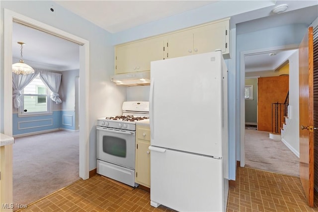 kitchen with hanging light fixtures, light colored carpet, white appliances, and cream cabinetry