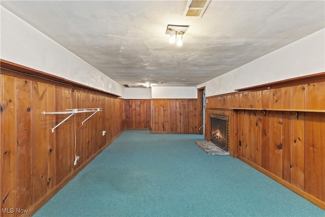 bonus room with light carpet and wood walls