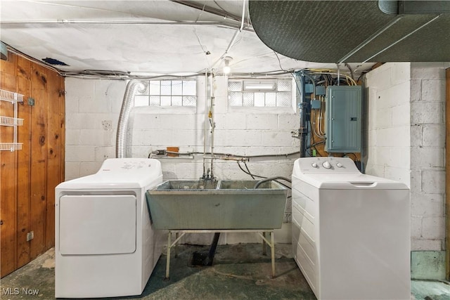 clothes washing area featuring washing machine and clothes dryer, electric panel, and sink