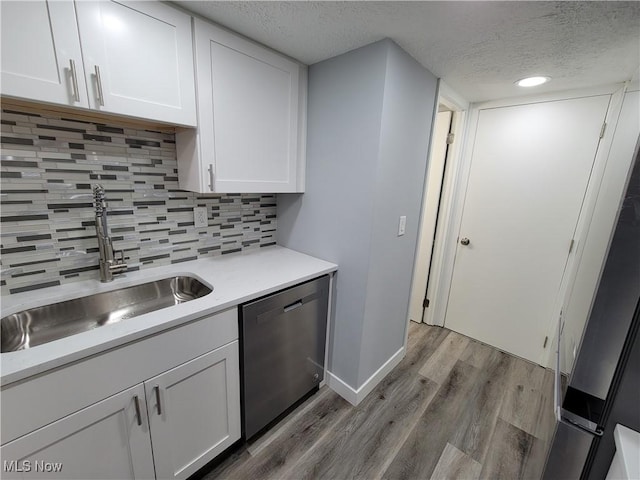 kitchen with dishwasher, sink, and white cabinets