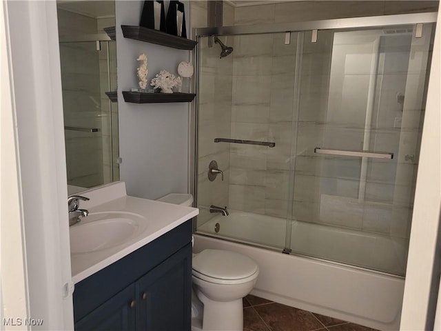 full bathroom featuring enclosed tub / shower combo, vanity, tile patterned floors, and toilet