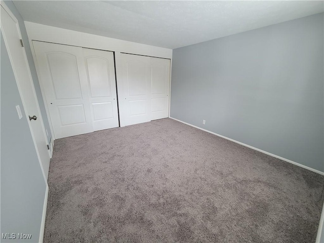 unfurnished bedroom featuring a closet and carpet flooring