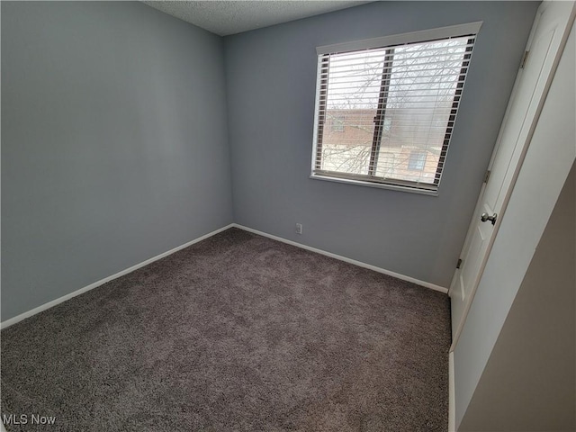 carpeted spare room with a textured ceiling