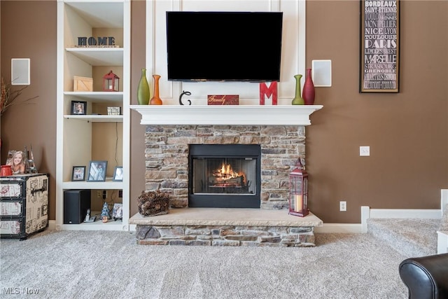 living room with built in shelves, carpet flooring, and a fireplace