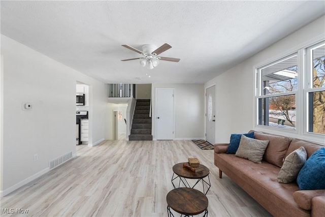 living room featuring light hardwood / wood-style floors and ceiling fan