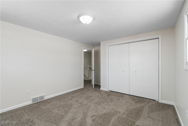 unfurnished bedroom with a closet and carpet