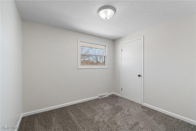 empty room featuring carpet floors and a textured ceiling