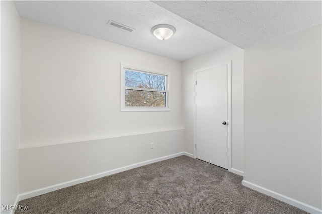 carpeted spare room featuring a textured ceiling