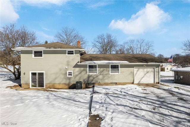 snow covered rear of property with central AC unit