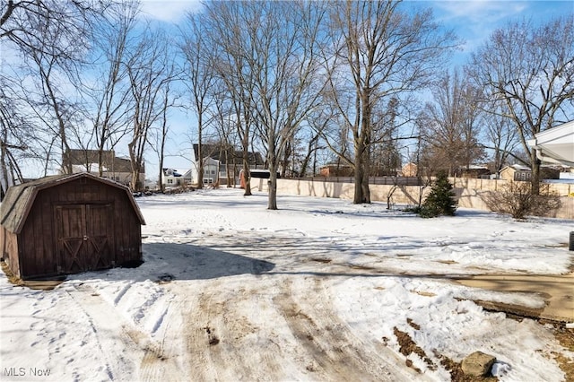 yard layered in snow featuring a storage unit