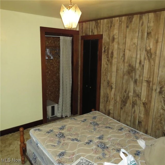 bedroom with wooden walls, a closet, and carpet flooring