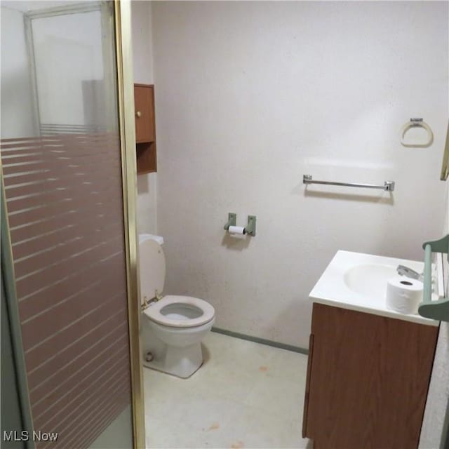 bathroom with vanity, an enclosed shower, and toilet