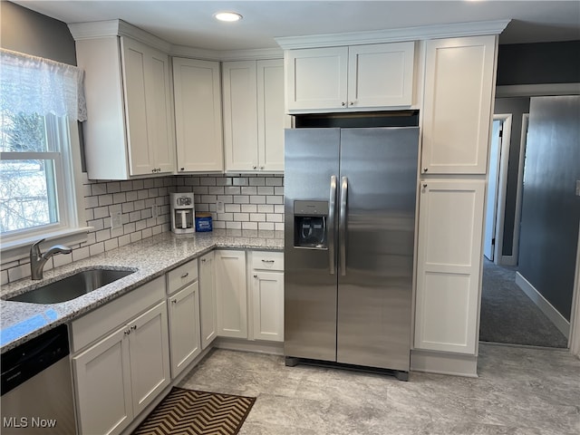 kitchen featuring light stone counters, sink, white cabinets, and appliances with stainless steel finishes