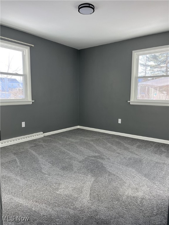 empty room with baseboard heating and carpet floors