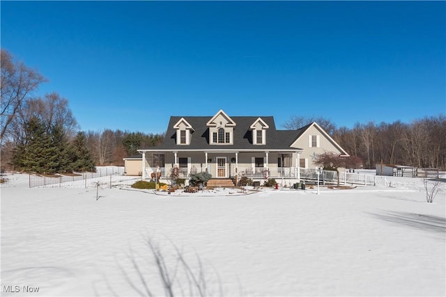 snow covered house featuring a porch