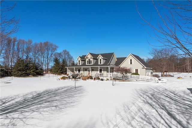 snow covered back of property featuring a porch