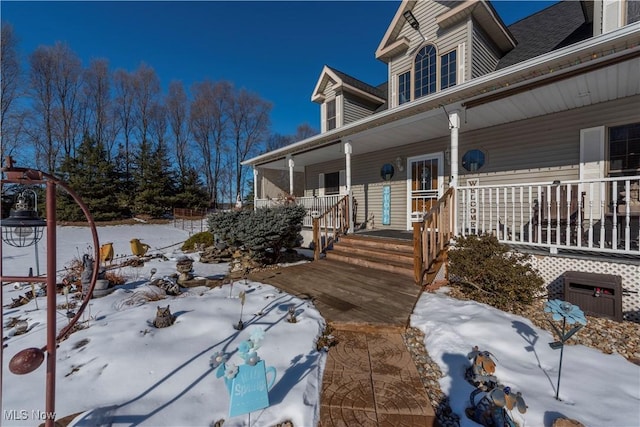 view of snow covered exterior featuring covered porch