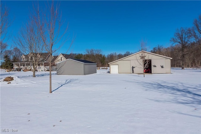 snow covered structure featuring a garage