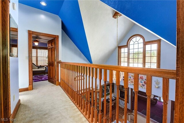 corridor with carpet flooring and vaulted ceiling