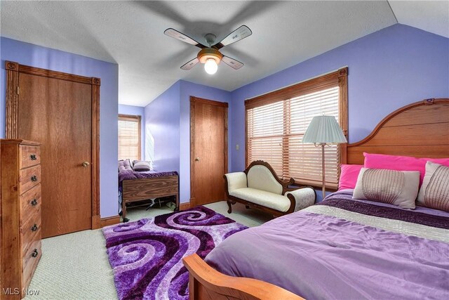 bedroom with ceiling fan, light colored carpet, and lofted ceiling