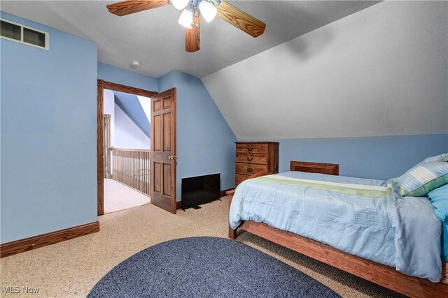 bedroom with ceiling fan, carpet flooring, and vaulted ceiling