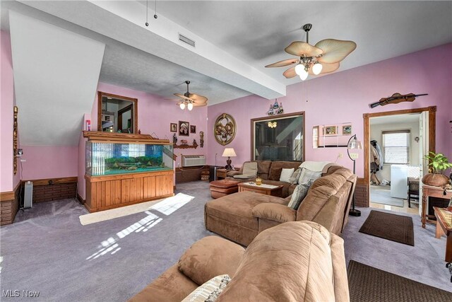 living room with a wall mounted air conditioner, carpet floors, and ceiling fan