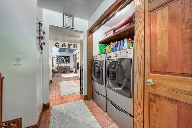 laundry room with light tile patterned floors, independent washer and dryer, and a textured ceiling