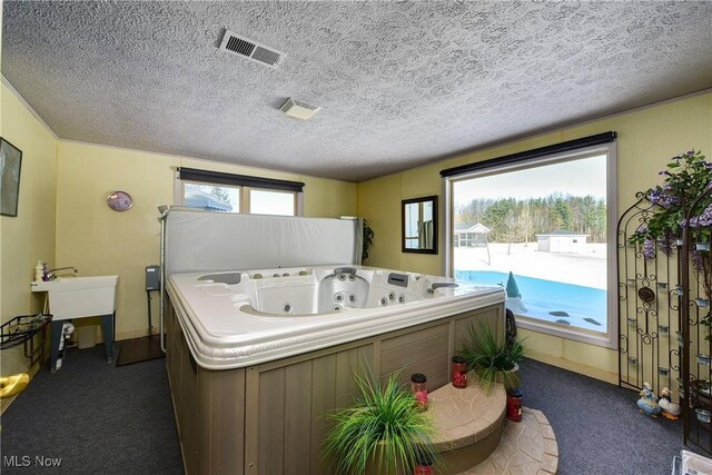 bathroom with a textured ceiling and a bathtub