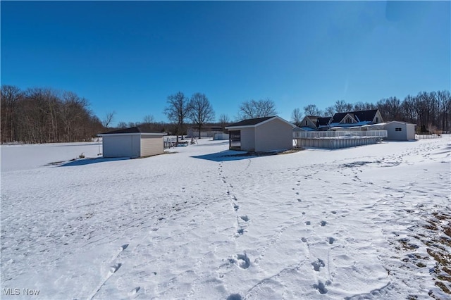 yard covered in snow with a storage shed