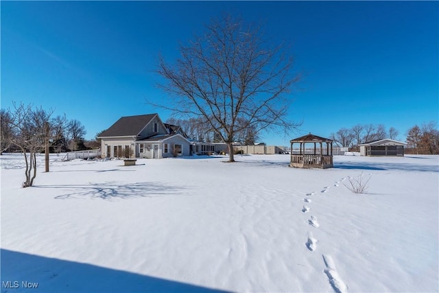 yard layered in snow with a gazebo