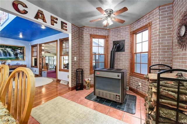 interior space with a wood stove and brick wall