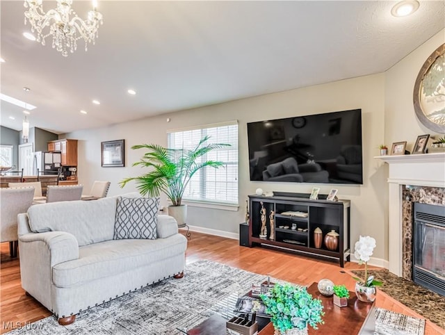 living room with hardwood / wood-style floors, a premium fireplace, and a chandelier