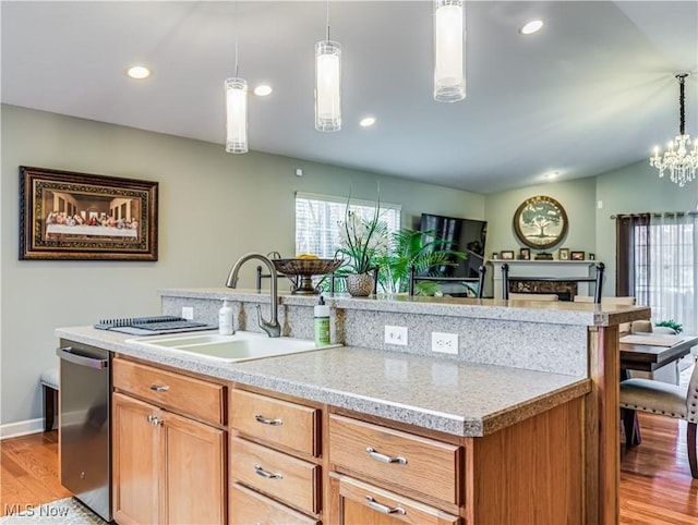 kitchen featuring dishwasher, sink, pendant lighting, and light hardwood / wood-style floors