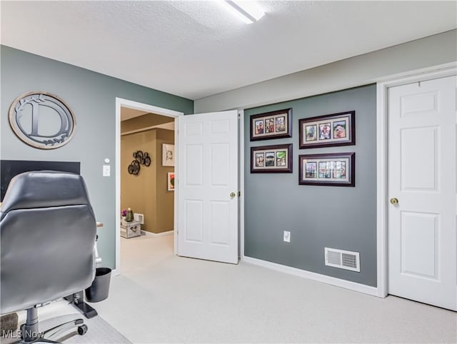 office with light carpet and a textured ceiling