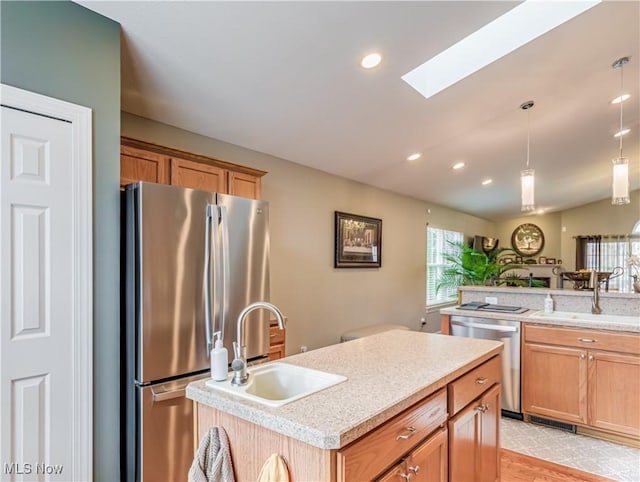 kitchen with sink, a kitchen island, light hardwood / wood-style floors, and appliances with stainless steel finishes