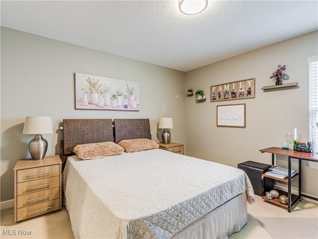 bedroom featuring light carpet and a textured ceiling