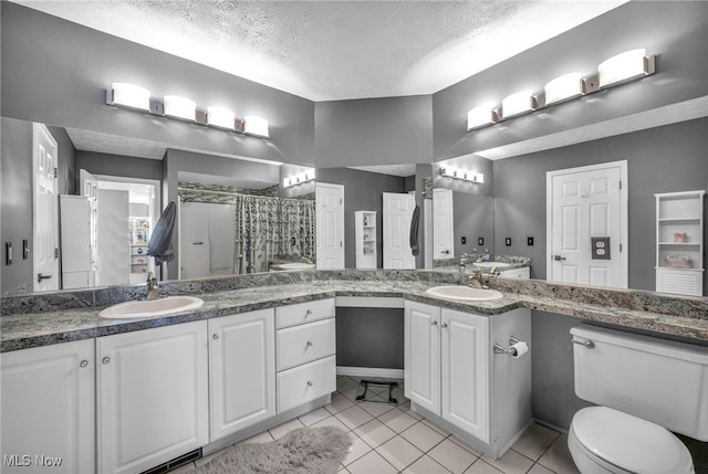 bathroom with toilet, a textured ceiling, vanity, a shower with shower curtain, and tile patterned flooring