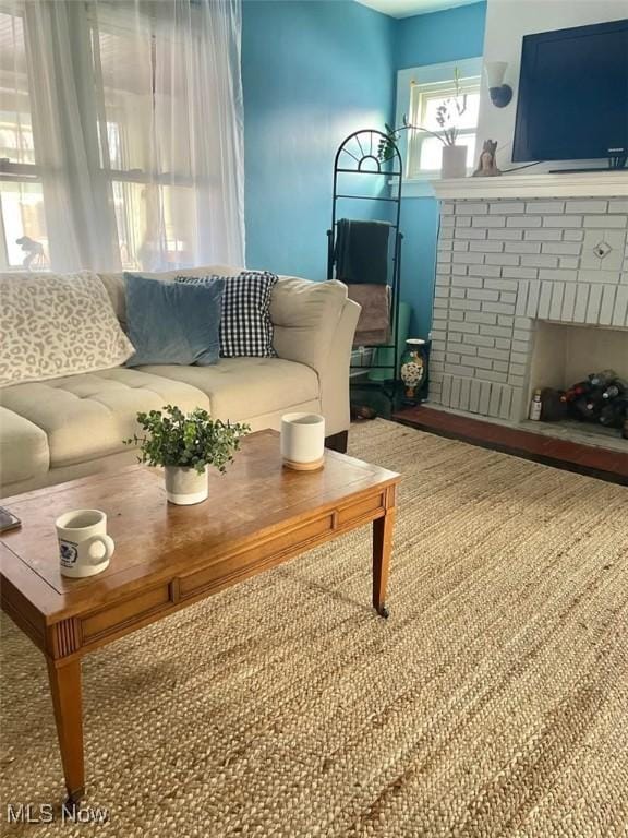 living room with a brick fireplace