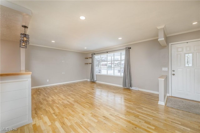 unfurnished living room featuring ornamental molding and light wood-type flooring