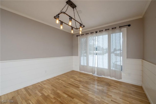 unfurnished room with ornamental molding, hardwood / wood-style floors, and a notable chandelier