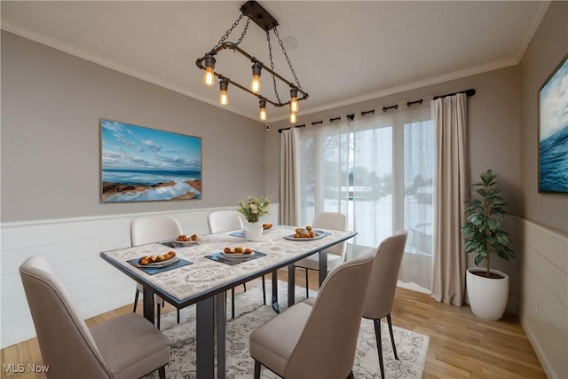 dining area featuring crown molding, light hardwood / wood-style floors, and a chandelier