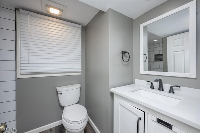 bathroom featuring vanity, wood-type flooring, and toilet