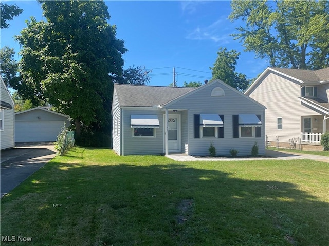 view of front of property with an outbuilding, a garage, and a front lawn