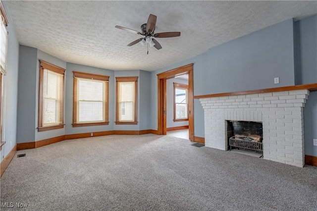 unfurnished living room with a healthy amount of sunlight, light carpet, and a brick fireplace