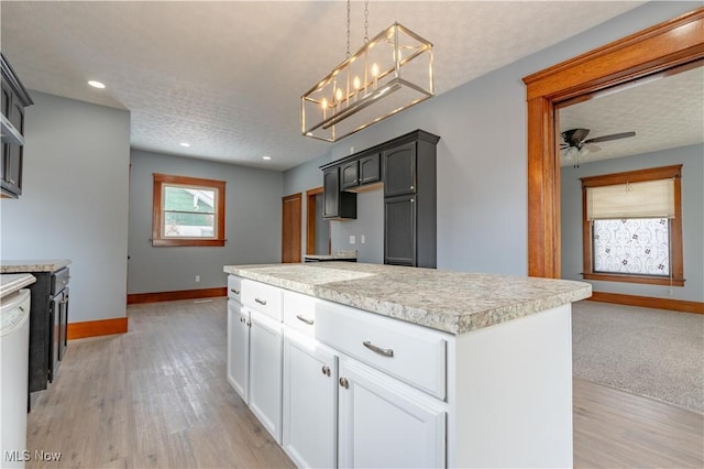 kitchen with pendant lighting, light hardwood / wood-style flooring, ceiling fan, dishwasher, and white cabinets