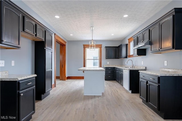 kitchen featuring pendant lighting, light hardwood / wood-style floors, a textured ceiling, a kitchen island, and stainless steel dishwasher