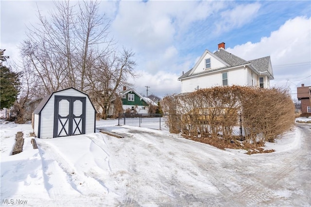 yard covered in snow featuring a storage shed